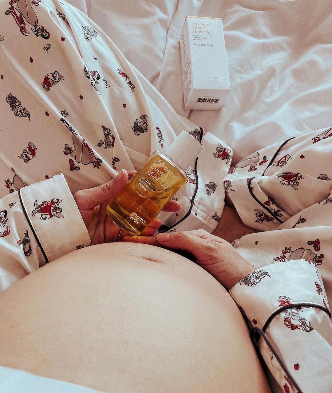 Sarah massaging Mamaway Advanced Stretch Mark Oil onto her belly